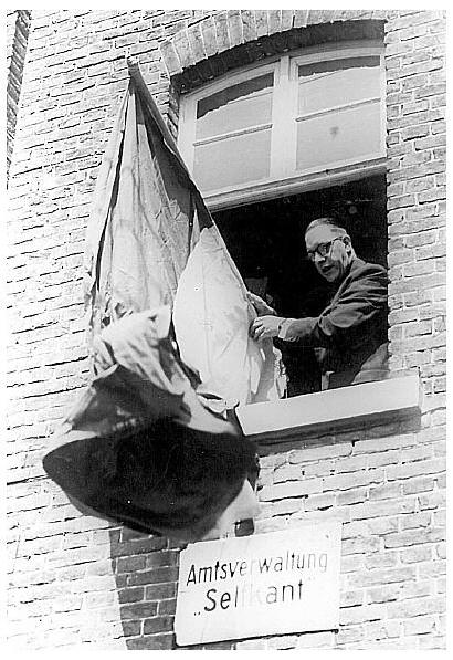 23. April 1949: Landdrost Hubert Dassen hängt um 12 Uhr mittags die niederländische Fahne an sein Amtsgebäude in Selfkant.